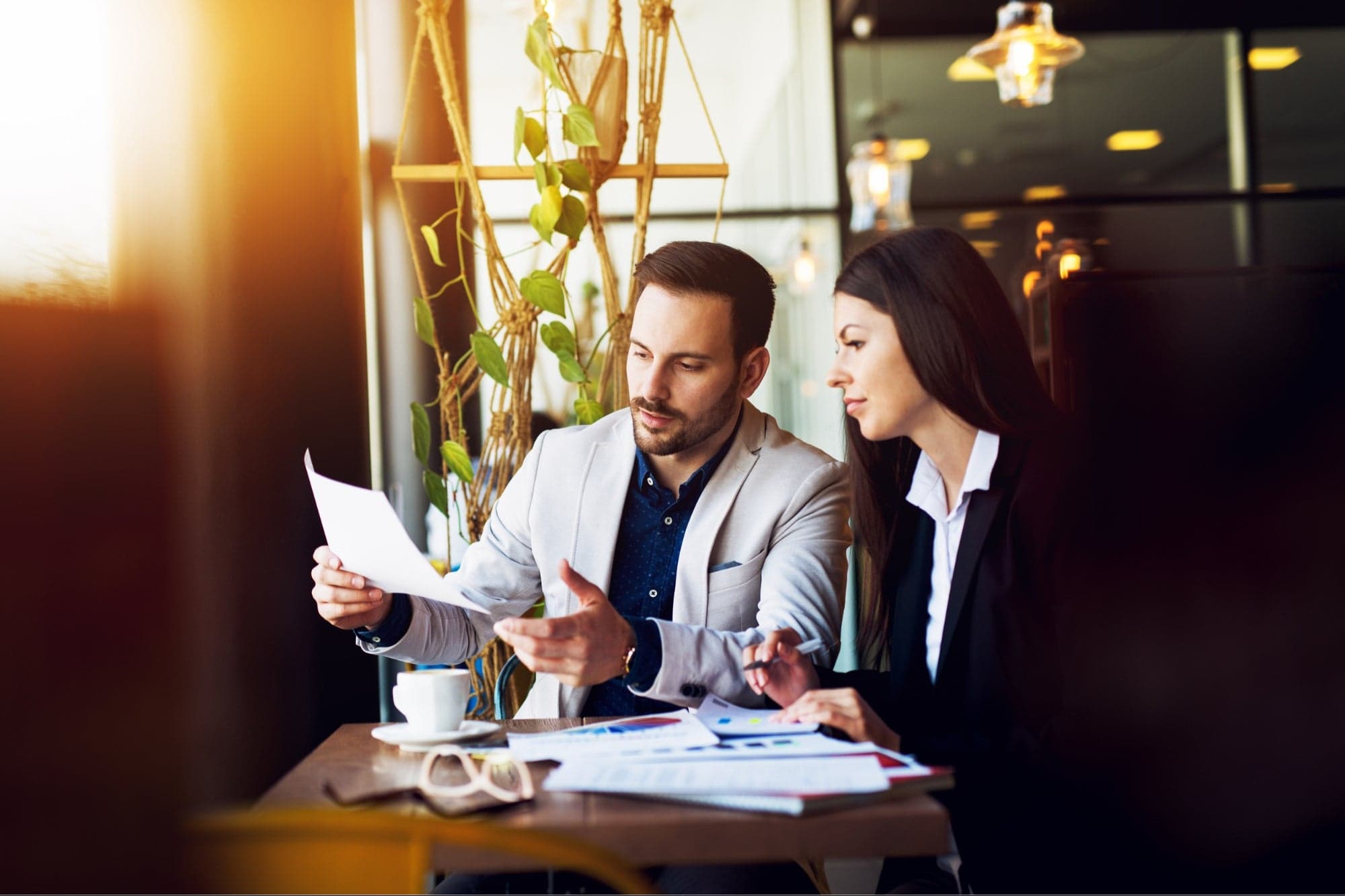 Business lunch. Business people sitting at table at restaurant looking at each other discussing